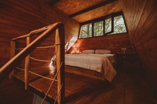 a bedroom with a bed in a wooden cabin at Eco Village In The Forest in Lagodekhi