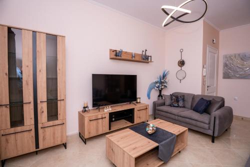 een woonkamer met een bank en een flatscreen-tv bij Zoes Luxury Apartment Corfu in Ágios Rókkos