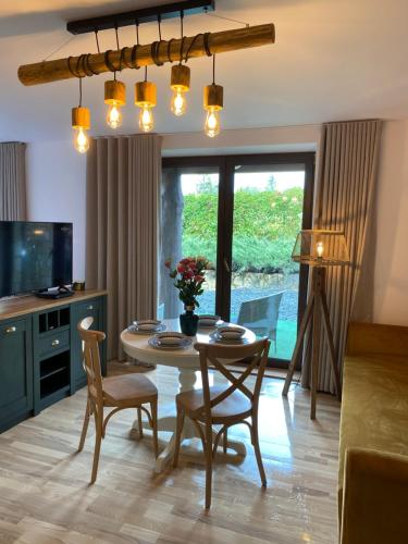 a living room with a table and chairs and a television at Anielski Zakątek Solina - balia z jacuzzi i sauna w cenie pobytu in Solina