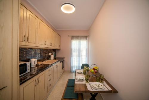 a small kitchen with a table and a counter top at Zoes Luxury Apartment Corfu in Agios Rokkos