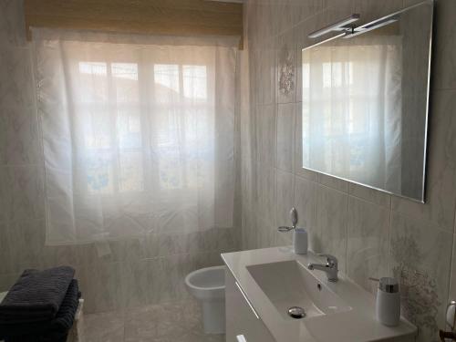 a bathroom with a sink and a toilet and a mirror at Apartamento en Rias Baixas-Aguiño-Ribeira in Ribeira
