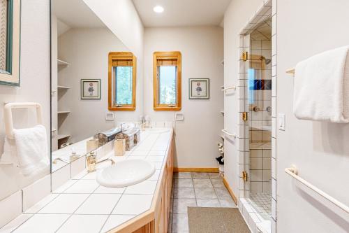 a white bathroom with a sink and a shower at Kobza's Quandary View in Breckenridge