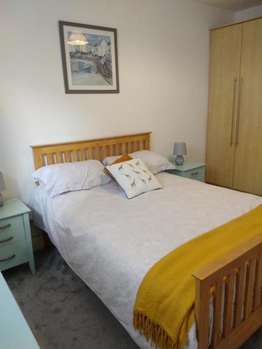 a bed in a bedroom with two tables and a bedspread at Town centre one bed apartment in Dungarvan