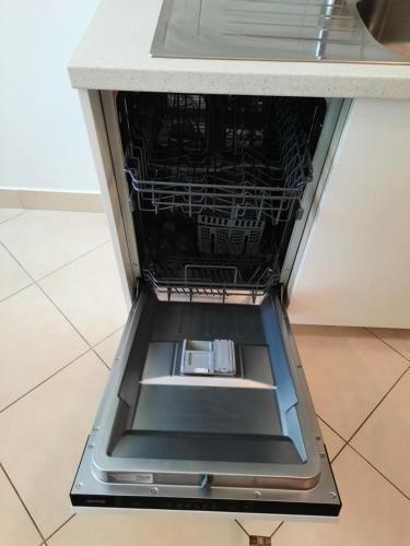 an empty dishwasher in a counter in a kitchen at Apartman Lovran in Lovran