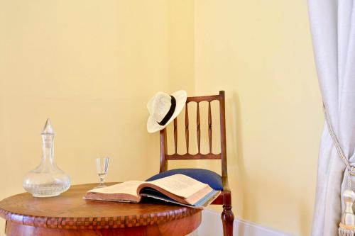 a hat sitting on top of a table with a book at History House in Corfu Town