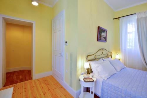 a bedroom with a bed and a table and a window at History House in Corfu Town