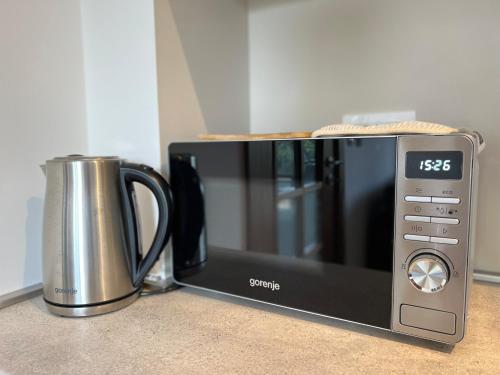 a microwave sitting on a counter next to a coffee pot at Zia Apartments in Bar