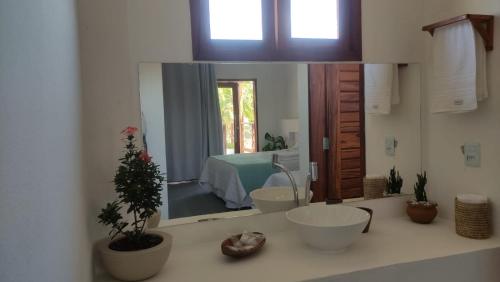 a bathroom with a sink with a mirror and a bed at Casa Morica! Casa nova com Piscina! in Icaraí
