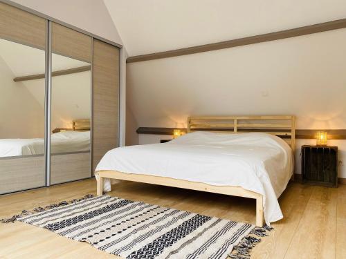 une chambre avec un grand lit blanc et un miroir dans l'établissement Côte d’Opale -Maison chaleureuse «au bois dormant», à Wadenthun