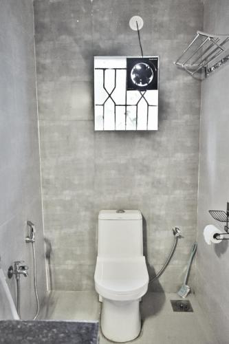 a bathroom with a toilet and a picture on the wall at SOLS Backyard in Arambol