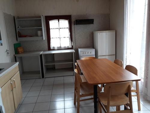 uma cozinha com uma mesa de madeira e um frigorífico em F 106 Vendégház em Fertőhomok