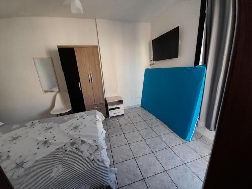 Zimmer mit einem Bett und einer blauen Tür in der Unterkunft Apartamento Temporada Praia do Morro in Guarapari