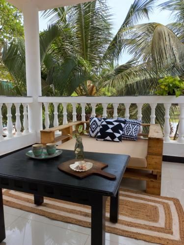 a coffee table on a balcony with palm trees at SOLS Backyard in Arambol