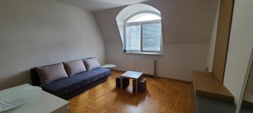 a living room with a blue couch and a window at Cozy studio apartment at center of Bijeljina in Bijeljina