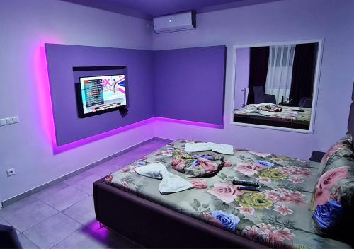 a room with a bed and a tv on a wall at Motel Villa STAR in Gjilan