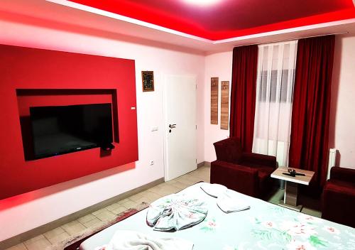 una camera con una parete rossa, un letto e una sedia di Motel Villa STAR a Gnjilane