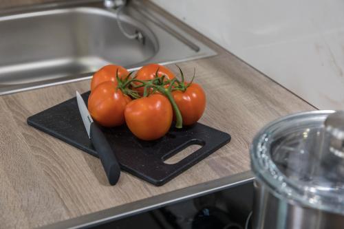 un par de tomates en una tabla de cortar con un cuchillo en Apartment Citar, en Poreč