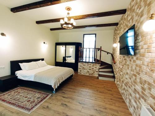 a bedroom with a bed and a brick wall at Merlot Apartment in Cricova