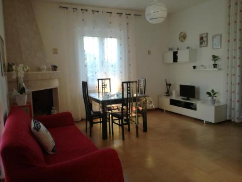 Una sala de estar con un sofá rojo y una mesa. en Villa Leo, en Ostuni