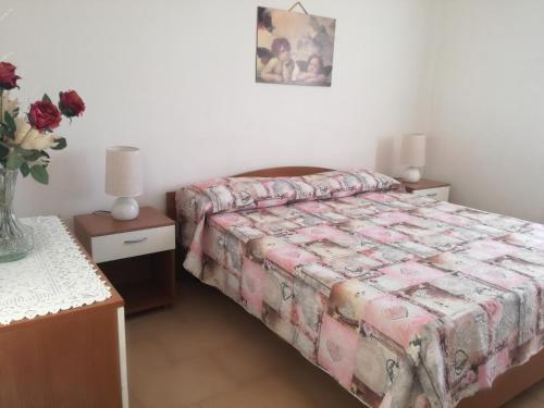 Un dormitorio con una cama y una mesa con flores. en Villa Leo, en Ostuni