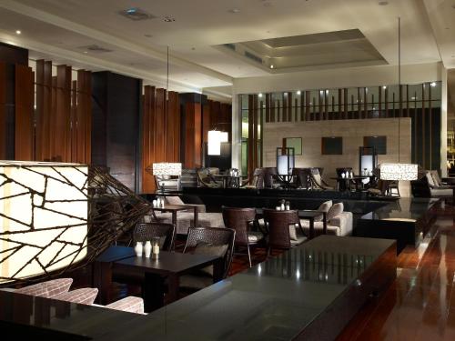 a restaurant with tables and chairs and a bar at Silks Place Yilan in Yilan City
