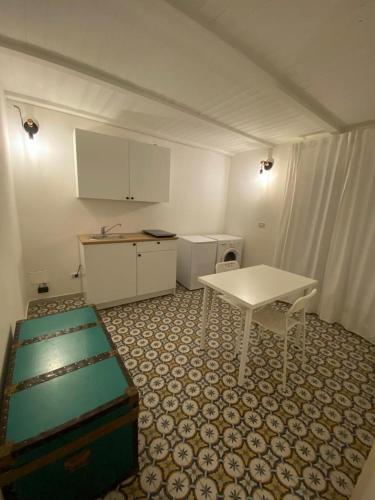 a kitchen with a white table and a table and chairs at fiori catene tra le torri in Conversano
