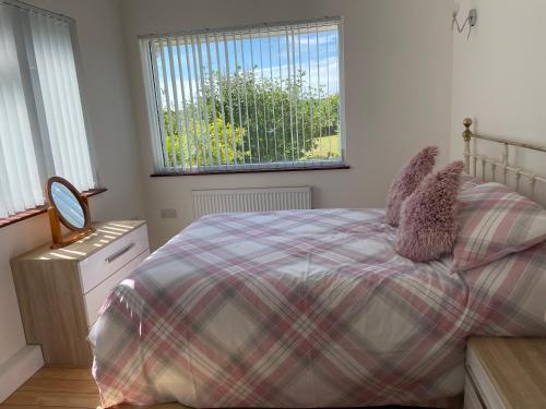 um quarto com uma cama e uma janela em Meadowside Lodge with Hot Tub em Truro