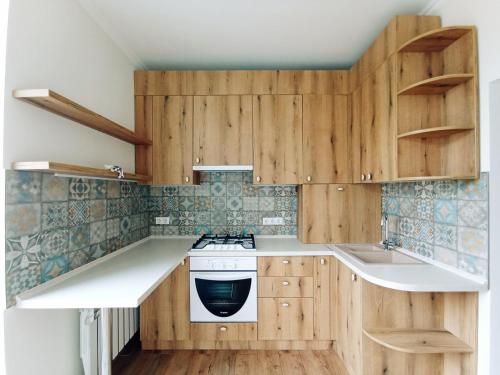 a kitchen with wooden cabinets and a stove at Merlot Apartment in Cricova