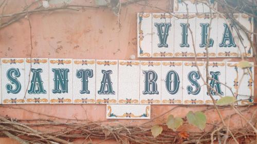 a street sign on the side of a building at Vila Santa Rosa Guest House in Ilhabela