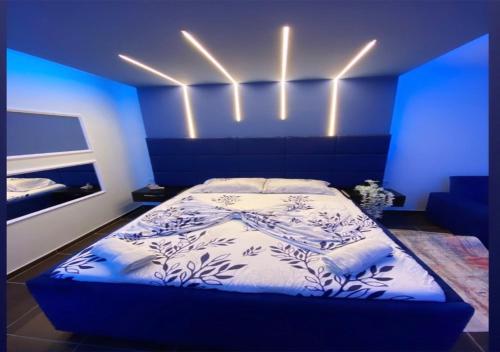 Un dormitorio con una cama con luces azules. en Motel Villa STAR en Gjilan