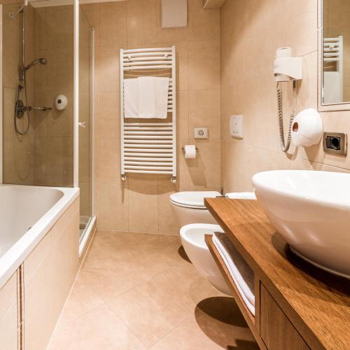 a bathroom with a sink and a toilet and a shower at Linder Cycling Hotel in Selva di Val Gardena