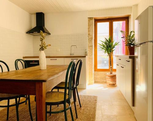 a kitchen with a wooden table and chairs at The Gate House & Winery in Santenay