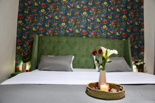 uma cama com um vaso de flores e velas sobre uma mesa em F&H 2 Bedroom cozy - Kigali apartment unit em Kigali