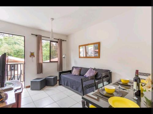 a living room with a couch and a table at Stúdio Petrópolis, Alameda das Pedras in Petrópolis