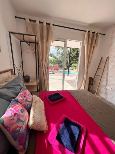 a bedroom with a bed with a red blanket at Les Vanniers: Papaye - KARITÉ in Baie-Mahault