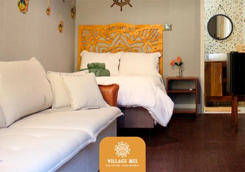 メーウ島にあるPousada Village Melのベッドルーム1室(大型ベッド1台、木製ヘッドボード付)