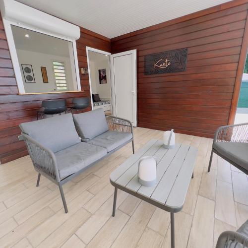 a living room with a couch and a table at Les Vanniers: Papaye - KARITÉ in Baie-Mahault