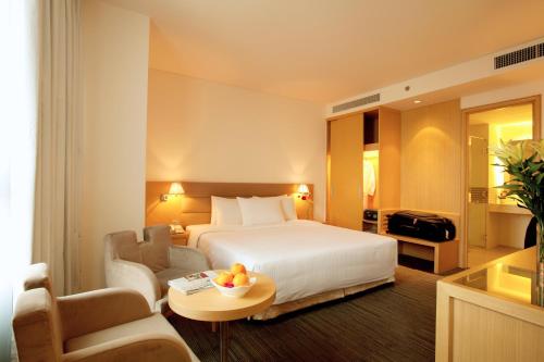 a hotel room with a bed and a table and chairs at Liberty Central Saigon Centre Hotel in Ho Chi Minh City