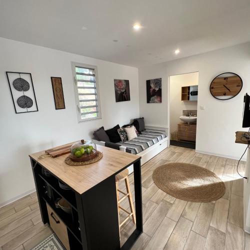 a living room with a couch and a table at Les Vanniers: Papaye - KARITÉ in Baie-Mahault
