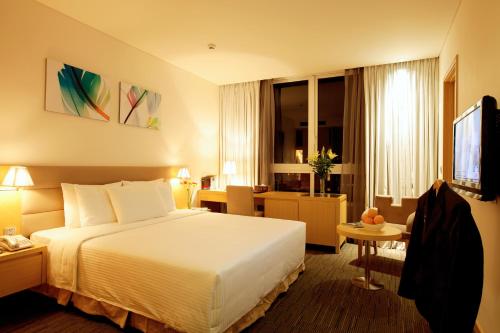 a hotel room with a bed and a television at Liberty Central Saigon Centre Hotel in Ho Chi Minh City
