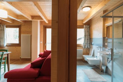 a living room with a red couch and a bathroom at Chalet Gaspard in Valtournenche