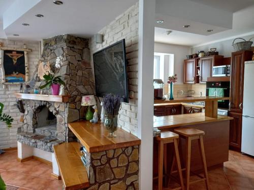 a kitchen and a living room with a stone fireplace at Dom gościnny u Krupów in Polańczyk