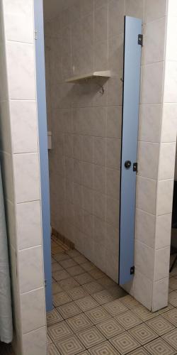 baño con ducha y puerta azul en Y Doc at World Horizons Community Hub, en Llanelli