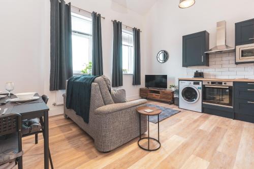 a living room with a couch and a table at The Old Band Accommodation in Higham Ferrers