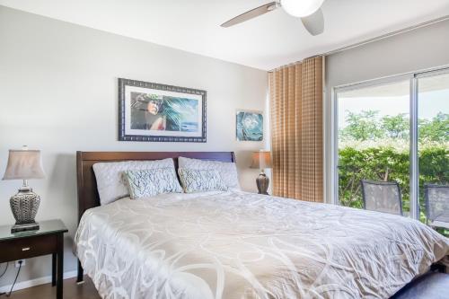 a bedroom with a large bed and a window at Greens At Waikoloa L101 in Waikoloa Village