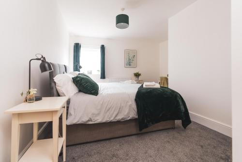 a bedroom with a large bed and a table at The Old Band Accommodation in Higham Ferrers