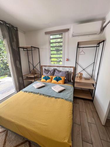 a bedroom with a large yellow bed in a room at Les Vanniers: Papaye - KARITÉ in Baie-Mahault