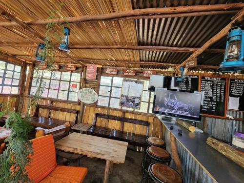 a restaurant with a bar with a table and a tv at Lillypond Camp in Elmenteita