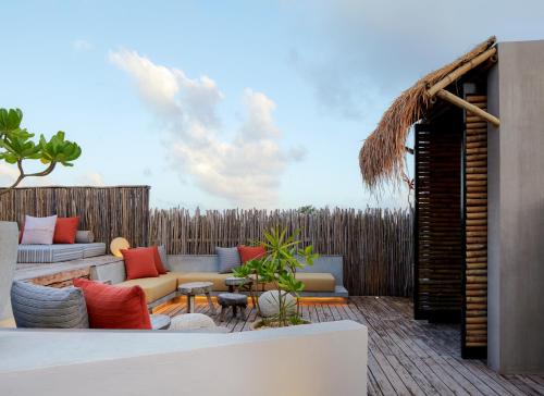 a patio with a couch and a table at Kimpton Aluna Resort Tulum, an IHG Hotel in Tulum