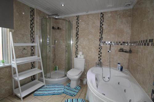 y baño con bañera, aseo y ducha. en St Ann's House en Rotherham